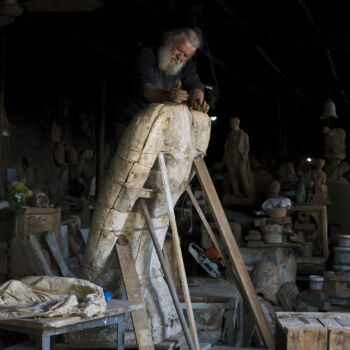 In this Thursday, Oct. 19, 2017 photo, sculptor and ceramicist Haralambos Goumas works on a huge terracotta eagle in a mould, at his workshop, in the Egaleo suburb of Athens. (AP Photo/Petros Giannakouris)