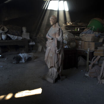 In this Friday, Nov. 20, 2017 photo, a dog lies next to a terracotta statue of Erato, one of the nine Muses of ancient Greek mythology, stands in Haralambos Goumas' ceramic workshop, in the Egaleo suburb of Athens. (AP Photo/Petros Giannakouris)