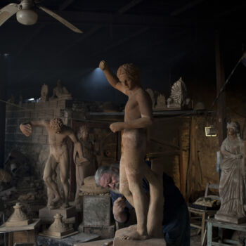 In this Tuesday, Dec. 19, 2017 photo, sculptor and ceramicist Haralambos Goumas works on a terracotta statue of Hermes, messenger of the ancient Greek gods, at his workshop in the Egaleo suburb of Athens. (AP Photo/Petros Giannakouris)