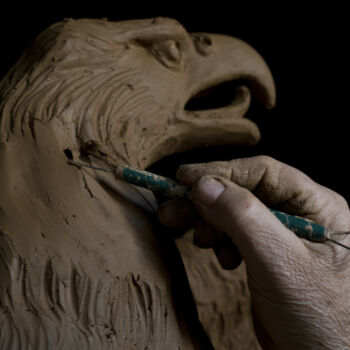 In this Tuesday, Nov. 14, 2017 photo, sculptor and ceramicist Haralambos Goumas works on a terracotta eagle, at his workshop, in the Egaleo suburb of Athens. (AP Photo/Petros Giannakouris)