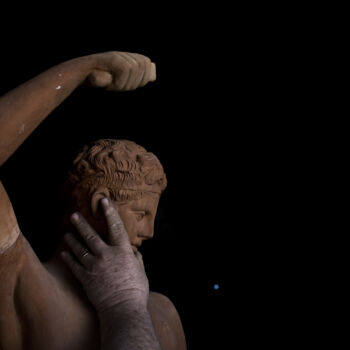 In this Tuesday, Dec. 19, 2017 photo, sculptor and ceramicist Haralambos Goumas touches a terracotta statue of Hermes, messenger of the ancient Greek gods, at his workshop in the Egaleo suburb of Athens. (AP Photo/Petros Giannakouris)