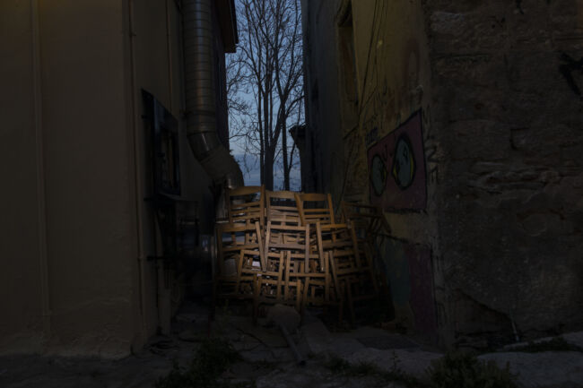 Chairs are stored outside a shuttered coffee shop in Plaka, district of Athens, on Monday, March 29, 2021. Restaurants, bars and cafes, whose nature it is to gather groups of people closely together, have remained shut since November when the Greek government imposed a second lockdown to curb the spread of COVID-19 infections. (AP Photo/Petros Giannakouris)