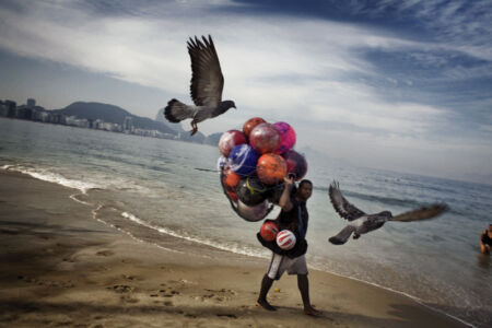 Francesco Zizola - A peddler walks along Copacabana Beach. Rio de Janeiro, Brazil. May 2008.