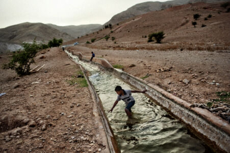 Francesco Zizola - A Palestininan child is playing in the water canal fed by the Al-Auja Spring. The spring, which once ran year around, began to fail after Israeli wells were sunk
West Bank. May 2010.