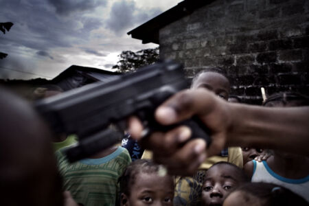 Francesco Zizola- A boy points a gun to another boy’s head for fun. Violence is extremely widespread in the region, as a consequence of the ongoing conflict between the guerrilla and the government forces. Rio San Juan, Colombia. July 2007.