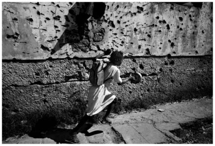 Francesco Zizola- Kuito, Bie province, Angola. June, 17th 2002.
A girl running in front of a building used to be the school.