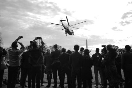 Visitors take photos and watch U.S. President Donald Trump depart on travel to West Point, New York from the South Lawn at the White House in Washington, U.S., December 12, 2020. REUTERS/Cheriss May